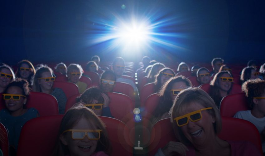 Bright Projector Light Beaming over people laughing and enjoying time in cinema